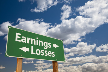 Earnings, Losses Green Road Sign Over Clouds