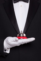 Waiter holding a service bell.