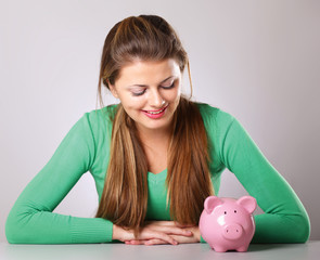Young beautiful woman with piggy bank (money box)