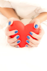 Beautiful woman's hands holding big red heart