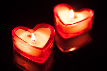 two burning candle hearts