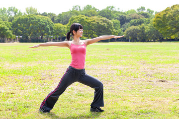 attractive asian woman stretching in the park