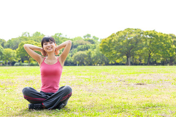 attractive asian woman stretching in the park