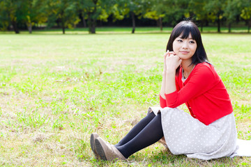attractive asian woman relaxing in the park
