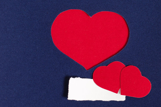 Three red hearts on dark blue