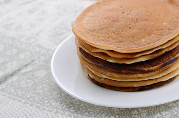 White plate with pankakes stack on the kitchen  table
