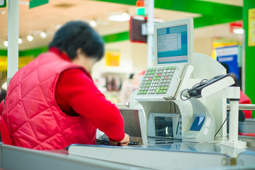 Cash desk with cashier and terminal in supermarket. Cashier coun