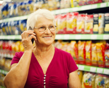 Senior woman on the phone at supermarket