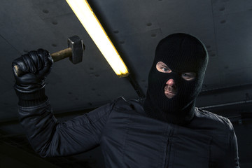 Fototapeta na wymiar masked criminal with hammer