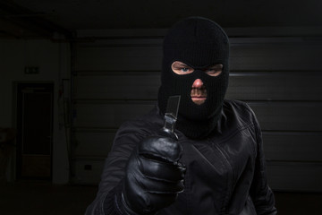 masked criminal holding knife
