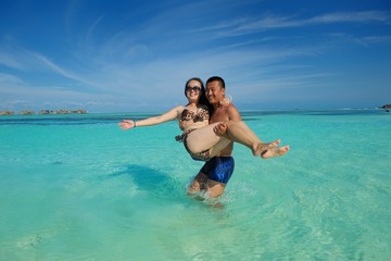 asian couple enjoying summer on beach