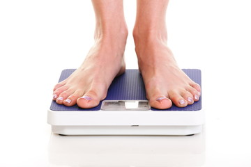 Woman feet and weight scale isolated on white background