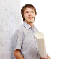 A young man near a diagram, holding a rolled draft