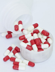 Pills spilling out of pill bottle isolated on white background