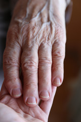 a young and senior hands holding each other