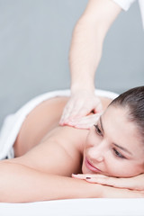 Woman enjoys back massage in spa salon