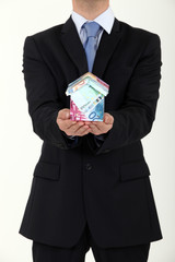 Businessman with a house made out of Euros