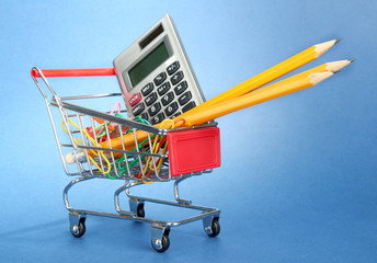 trolley with school equipment on blue background