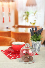 Chocolate pieces under glass cover and hot drink