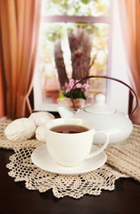 cup of tea with scarf on table in room