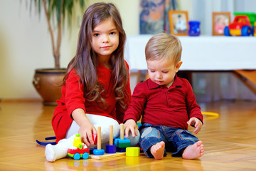 Naklejka premium beautiful brother and sister playing at home