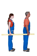 Man and woman carrying a plank of wood