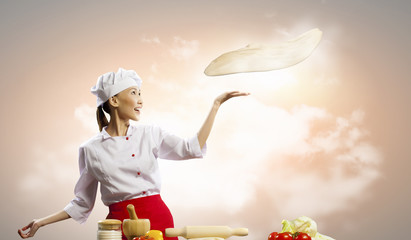 Asian female cook making  pizza
