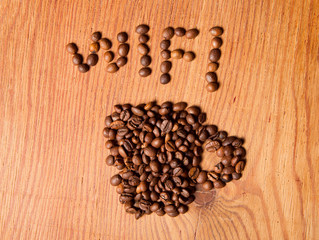 form a coffee cup made of coffee beans on the wood background