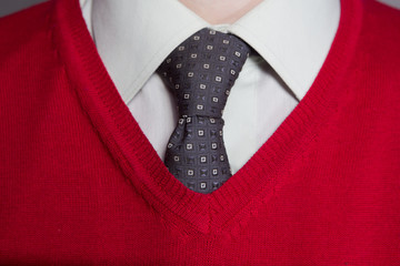 Man wearing white shirt, red sweater and necktie