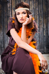 Obraz premium smoking actress in brown and orange boa
