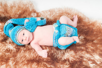 Newborn baby in knitted blue clothes