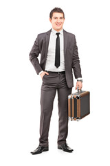 Full length portrait of a young businessman in suit holding a br
