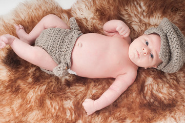 Newborn baby in knitted blue clothes