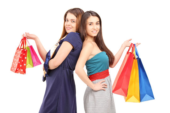 Two young females after shopping posing with bags