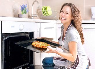 Happy Young Woman Cooking Pizza at Home