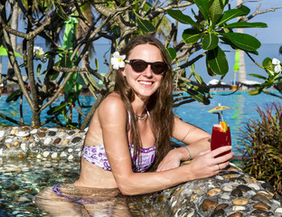 Woman with cocktail in pool