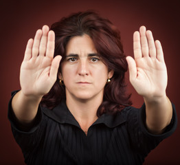 Hispanic woman with her two hands extended signaling to stop