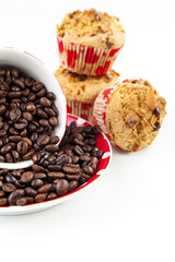Almond flakes muffins near a cup full of coffee beans