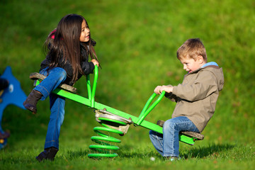 enfants jouant a la balançoire dans un parc de jeu
