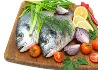 dorado fish with lemon and vegetables close-up on chopping board