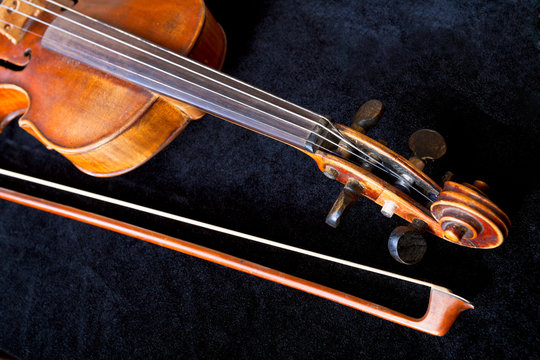 violin scroll and bow on black velvet