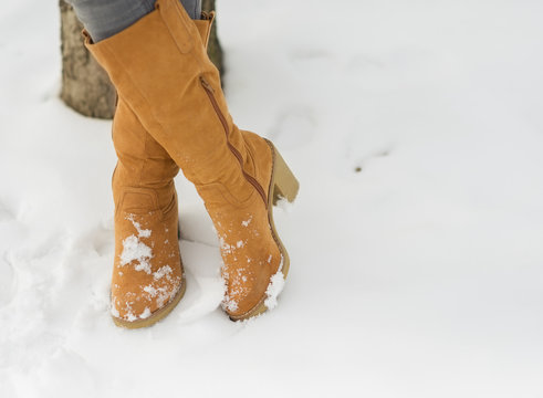 Closeup On Woman Legs In Winter Boots On Snow