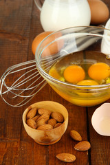 Broken egg in bowl and various ingredients next to them
