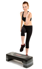 Young woman doing fitness exercises on stepper isolated on