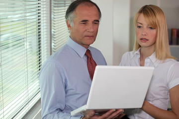 Fototapeta na wymiar Biznesmen patrząc na laptopie ze swoim asystentem