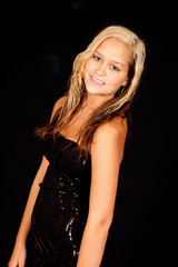 Naklejka premium blond woman in little black dress, smiling at the camera