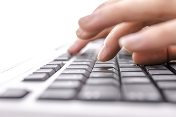 Detail of female fingers typing on keyboard