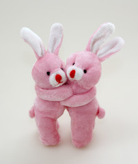 Two pink rabbits cuddling