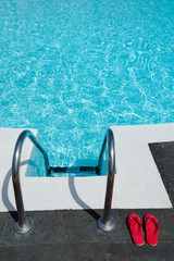 Red flip flops near tropical pool