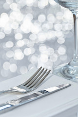 Fork and knife in elegant table setting with festive background